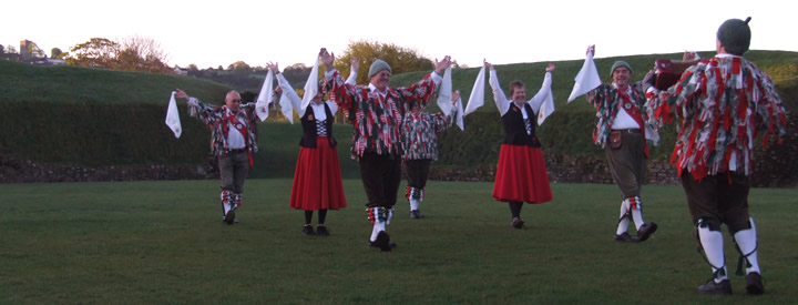 The Isca Morrismen and Cardif Ladies in Caerleon Roman Amphitheatre May 1st 2010. The rising sun just catching the church tower Christchurch.