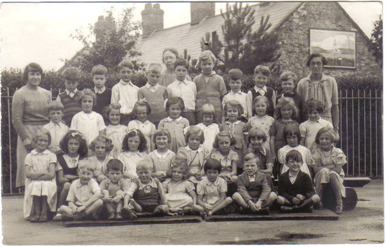 Evacuated children and teachers from Thorpe Hall Primary School, Highams Park, London, photographed in 1940 in Caerleon Infant School playground. Evacuees.